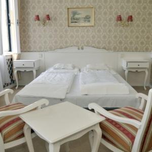 贝凯什乔包阜姆酒店的一间卧室配有两张白色的床和两把椅子
