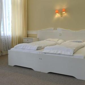 贝凯什乔包阜姆酒店的一间卧室配有两张带白色床单的床