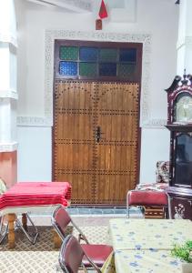 非斯Fes Hostel Zaouia的一间设有木门、椅子和时钟的房间