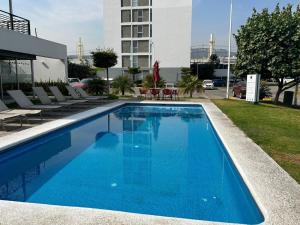 尔湾Luxurious Apartment Bardeen New Port Beach 1 Bedroom的一座带椅子的蓝色游泳池和一座建筑