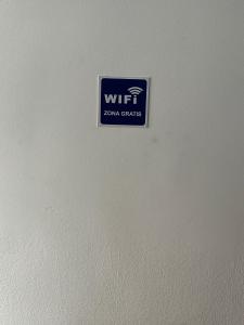 马德里Fast Single Rooms的白色墙边的标志