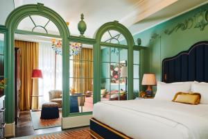 纽约The Fifth Avenue Hotel的一间卧室设有一张带绿色墙壁的大床