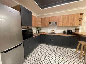 鲍里斯皮尔格雷斯公寓的厨房配有不锈钢冰箱和木制橱柜