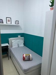 迪拜Short Stay Partition Room in Al Barsha 1 Near Mashreq Metro的一张位于带绿色和白色墙壁的房间的床铺