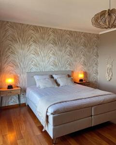 加乌拉Casa do Mundo Madeira的一间卧室配有一张大床,桌子上放着两盏灯