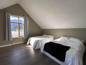戈尔登Mountain Magic的一间卧室设有两张床和窗户。