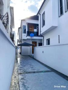 IbejuIVYs 4 Bedroom Luxury Entire Apartment Duplex with Wifi in Lekki的一条小巷,有建筑和雨伞