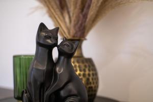 施韦特Lichterfüllte Erholungsoase für Groß und Klein的坐在花瓶旁的黑猫雕像