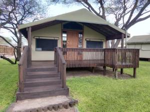 NtabisNako Okavango Guesthouse的一个小房子,设有门廊和甲板