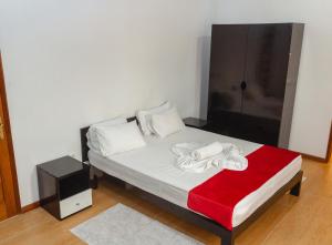 圣多美Baig's Guest House的一间卧室配有一张带红色毯子的床