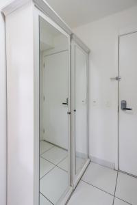 圣保罗SanLoft Expo Inn Tietê 03 Top 1的浴室内有玻璃门,铺有白色瓷砖