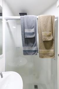圣保罗SanLoft Expo Inn Tietê 03 Top 1的浴室毛巾架上挂着三条毛巾