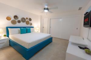 璜多里奥Marbella Juan Dolio Beachfront的一间卧室配有蓝色的床和电视