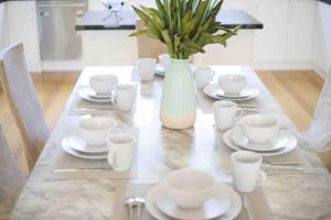 伯伍德Perfectly modern living home in Burwood的一张带白菜的桌子和一个带植物的花瓶