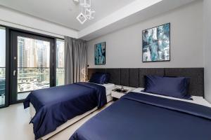 迪拜Luxurious 2BR apt with panoramic Marina view的一间卧室设有两张床和窗户。