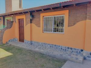 卡皮亚德尔德尔蒙特Cabañas Morada del Cerro的橙色的房子,有窗户和门