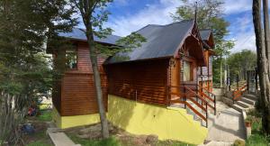 乌斯怀亚Alakalufes Estudio - Departamento completo en Ushuaia的一座黄色地基的小木房子