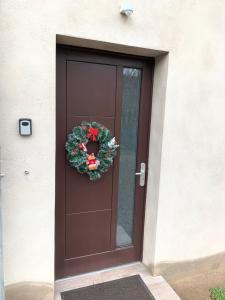 勒奥瓦尔德Gîte au cours d’eau的棕色的门,上面有圣诞花圈