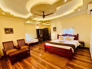 瓦尔卡拉Maadathil Cottages & Beach Resort的大房间设有两张床和一把椅子