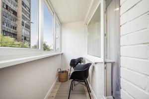 维尔纽斯Tyzenhauzu Apartment的小房间设有椅子和窗户