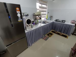 甘榜甘马挽JRC Homestay Kerteh的厨房配有不锈钢冰箱和水槽
