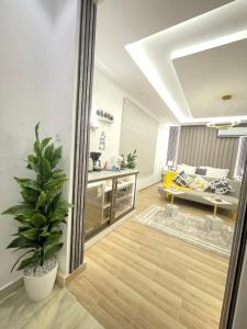 利雅德Riyadh modern studio的一间起居室,配有盆栽植物和厨房