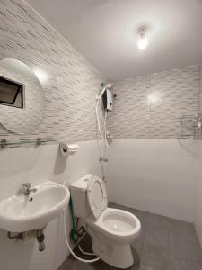 AbucayThe Doll House 2.0的白色的浴室设有卫生间和水槽。