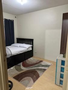 马尼拉Sorrento Oasis 2 BR的卧室配有一张床,地板上铺有地毯