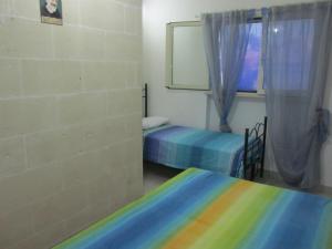 托雷奥沃Casa Salento Mare的客房设有两张床和窗户。
