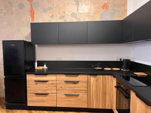 耶维克Apartamenty Rynek 18的厨房配有黑色台面和木制橱柜