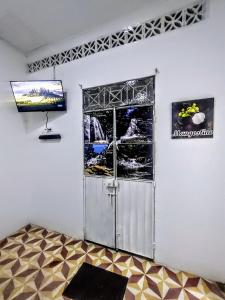 马里基塔SAN SENDERISMO ROOM的一间有门的房间,墙上有一台电视机