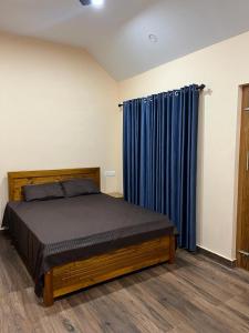 ThirunelliCoffee Bean Rest House的一间卧室配有床和蓝色窗帘