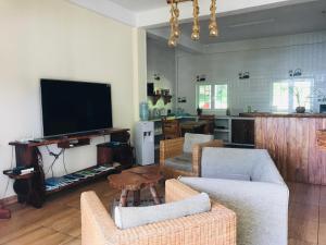 留尼汪Villa Des Flots的客厅配有沙发、电视和椅子