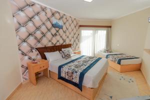 赫尔格达Andalusia Blue Beach Hurghada的酒店客房带两张床和一面墙