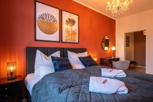 格拉maremar - Style Apartment im Zentrum - Luxus Boxspringbett - Arbeitsplatz - Highspeed WLAN的一间卧室配有一张带橙色墙壁的大床