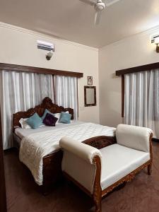 哈桑Amayaa Courtyard Homestay的一间卧室配有一张大床和一把椅子
