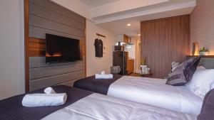 大阪住一難波南恵美須町駅前店的酒店客房设有两张床和一台平面电视。