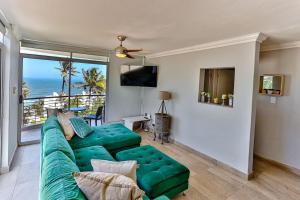 巴利托Seaside 96 - Family only的客厅设有绿色沙发,享有海景