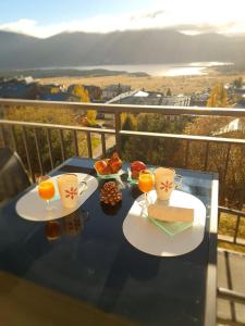 安格勒Appartement avec magnifique terrasse VUE LAC aux Angles的阳台上的桌子上放着两盘食物和饮料