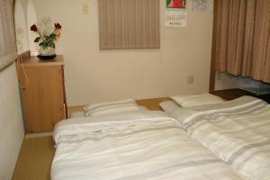 神户Private Inn Bambee的客房内的两张床拼在一起。