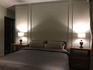 纳闽巴霍Hotel Sanset的一间卧室,两边都配有一张床和两盏灯