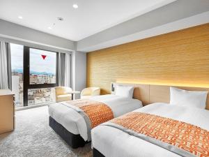 松山松山大和鲁内酒店的配有大窗户的酒店客房内的两张床