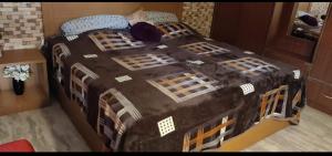 贾姆穆Simbha's Homestay的一间卧室配有一张大床和黑色棉被