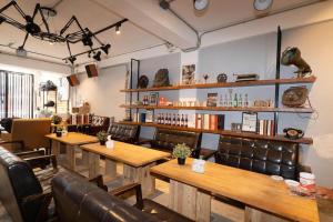 台中市薇薇青旅-嚞驫驛站的餐厅设有木桌和皮椅