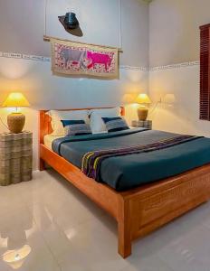 昆岛Chang's Hideaway homestay ConDao的一间卧室配有一张大床和两盏灯