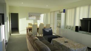 TuggeranongGREENWAY WATERS Apartments的客厅配有沙发和桌子