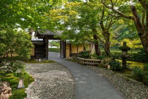 京都京都翠岚豪华精选酒店的公园里树木和建筑的走道