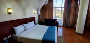 巴赫达尔Yiganda Hotel - Ethiopia的一间卧室设有一张床和一个大窗户