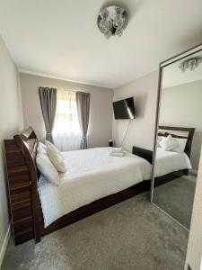 埃奇韦尔2 Double Bedroom Apartment in Edgware, London的一间卧室配有一张大床和镜子