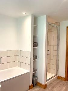 奥斯威斯3 Bedroom Bungalow in Llanrhaeadr Ym的设有带浴缸和淋浴的浴室。